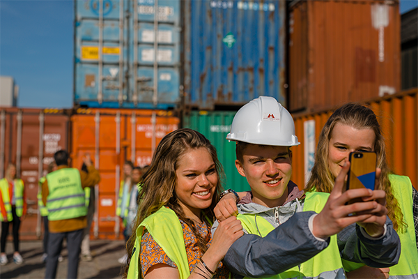 kids doing a selfie in front of containers